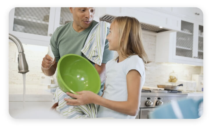 Familia lavando y secando los platos
